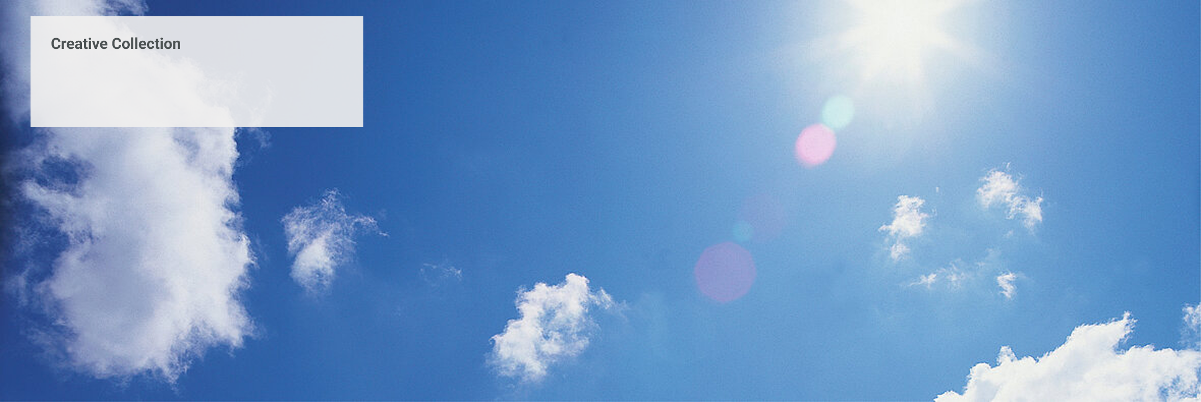 Blauer Himmel mit weißen Wolken und strahlender Sonne im oberen Bildrand
