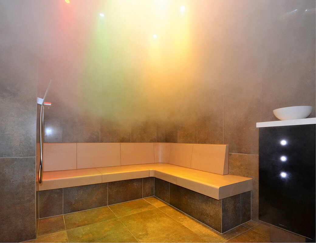 Moderne Dampfsauna mit warmem LED-Licht und Holzbänken für therapeutische Entspannung