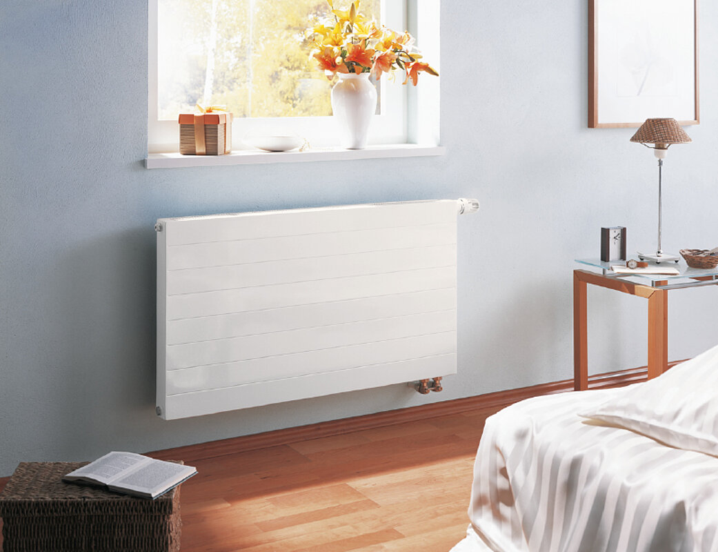 Weiße Design-Wandheizkörper in modernem Wohnzimmer mit Holzboden und minimalistischer Einrichtung