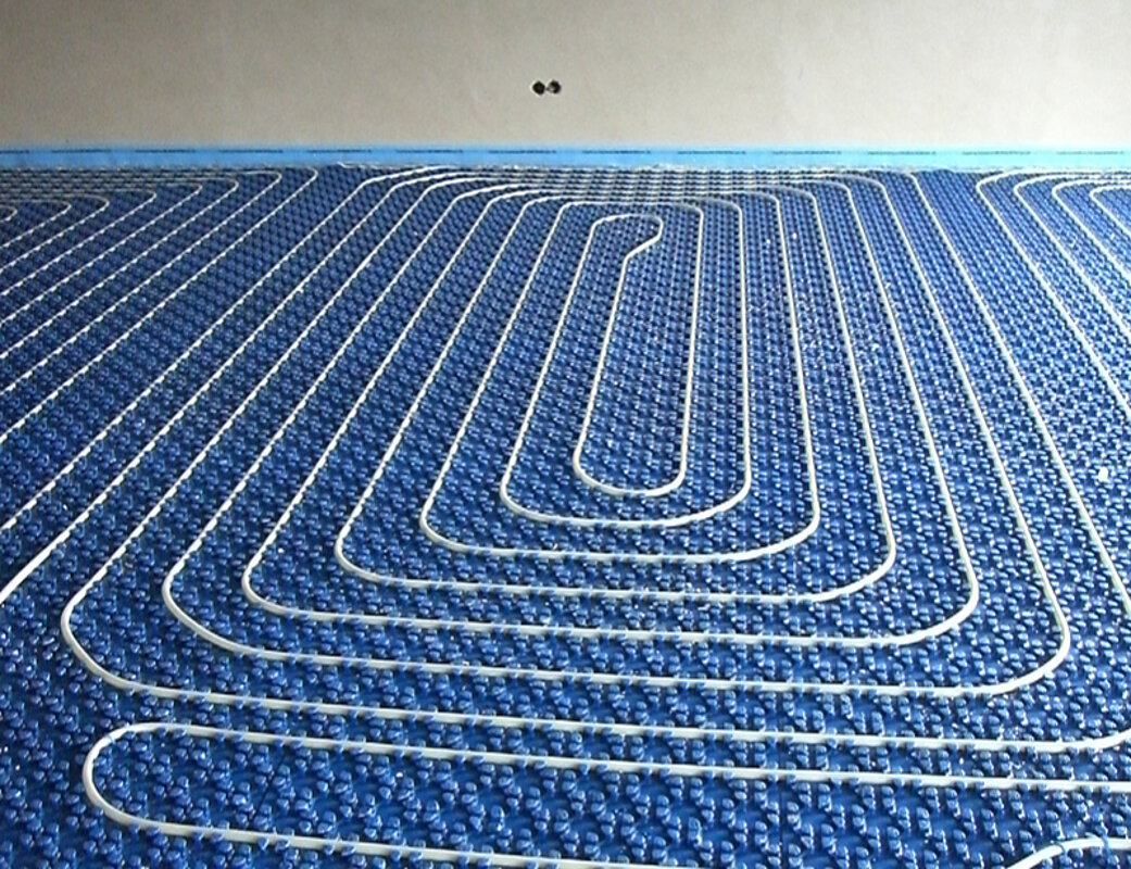 Blaue Heizungsrohre einer Fußbodenheizung vor der Installation unter dem Estrich