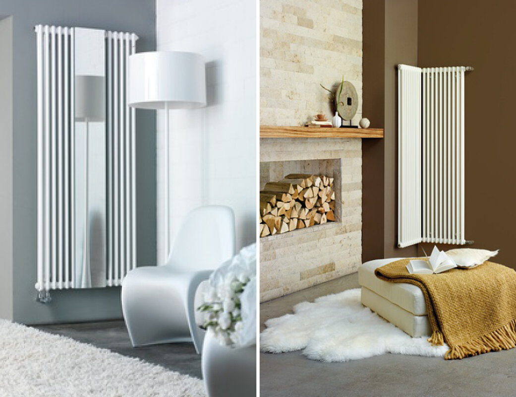 Vertikale Design-Heizkörper in Weiß neben modernem Kaminofen mit Holzvorrat