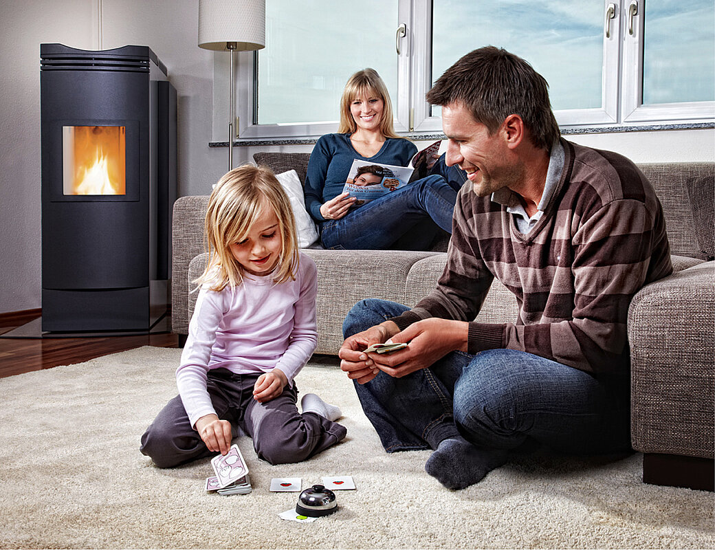 Familie genießt die Wärme vom modernen Kaminofen im Wohnbereich