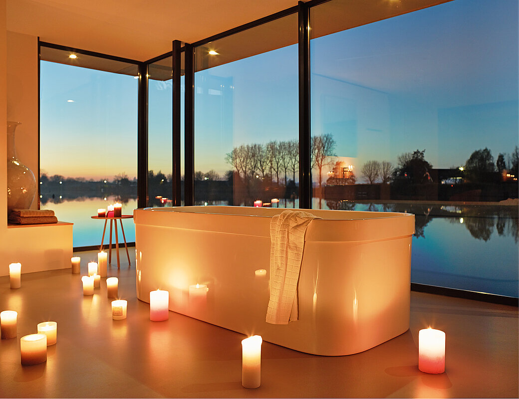 Luxusbadezimmer mit freistehender Designer-Badewanne und Panoramafenstern bei Sonnenuntergang